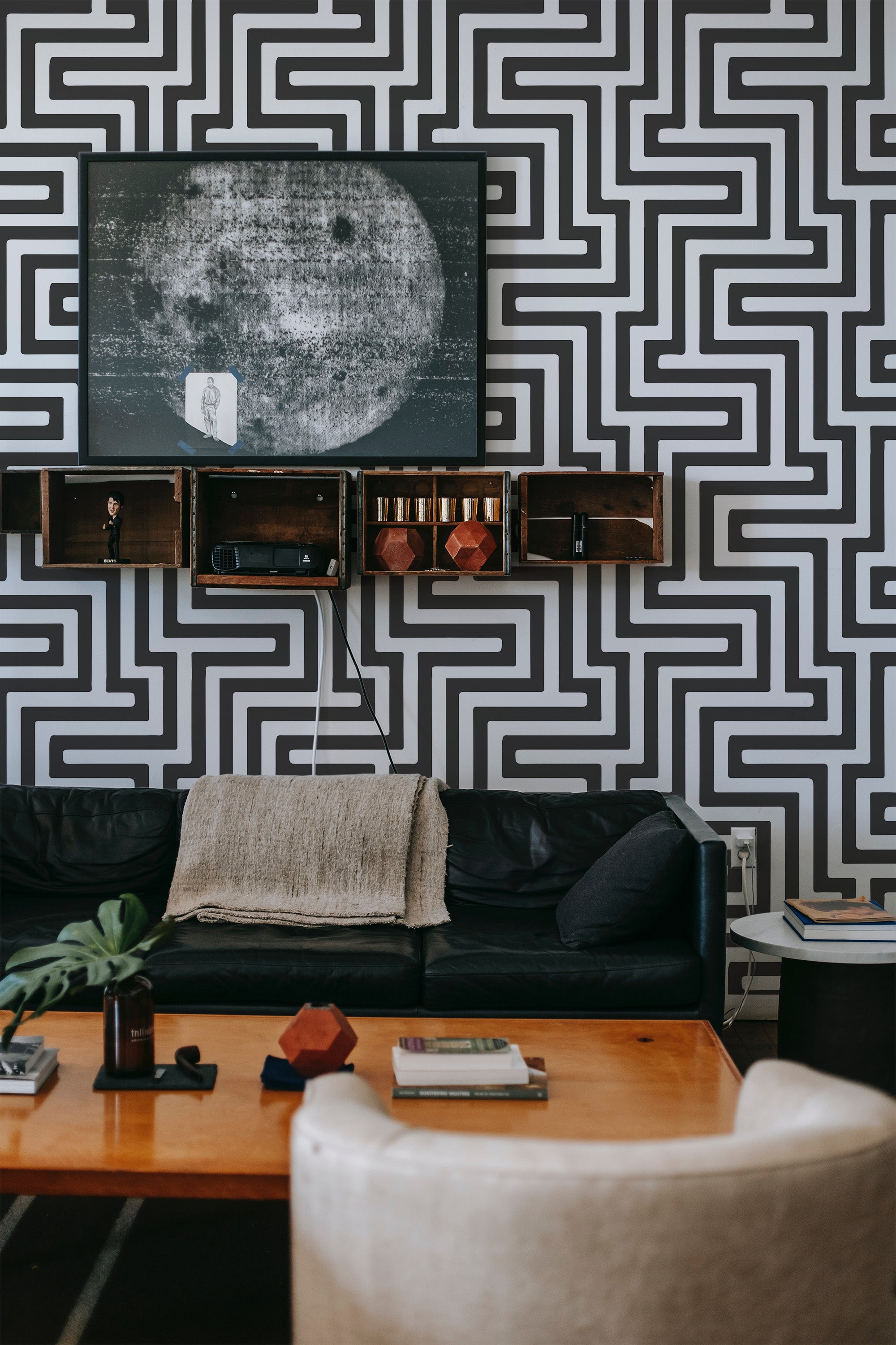 A room with black and white geometric wallpaper forming interlocking rectangular patterns, creating a bold, modern look that contrasts with the classic style of the furniture. traditional wallpaper.