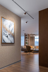 A softly textured wallpaper in the room has a subtle, delicate pattern of light-colored leaves against a neutral brown background, adding a warm and cozy feel to the space. Traditional wallpaper.