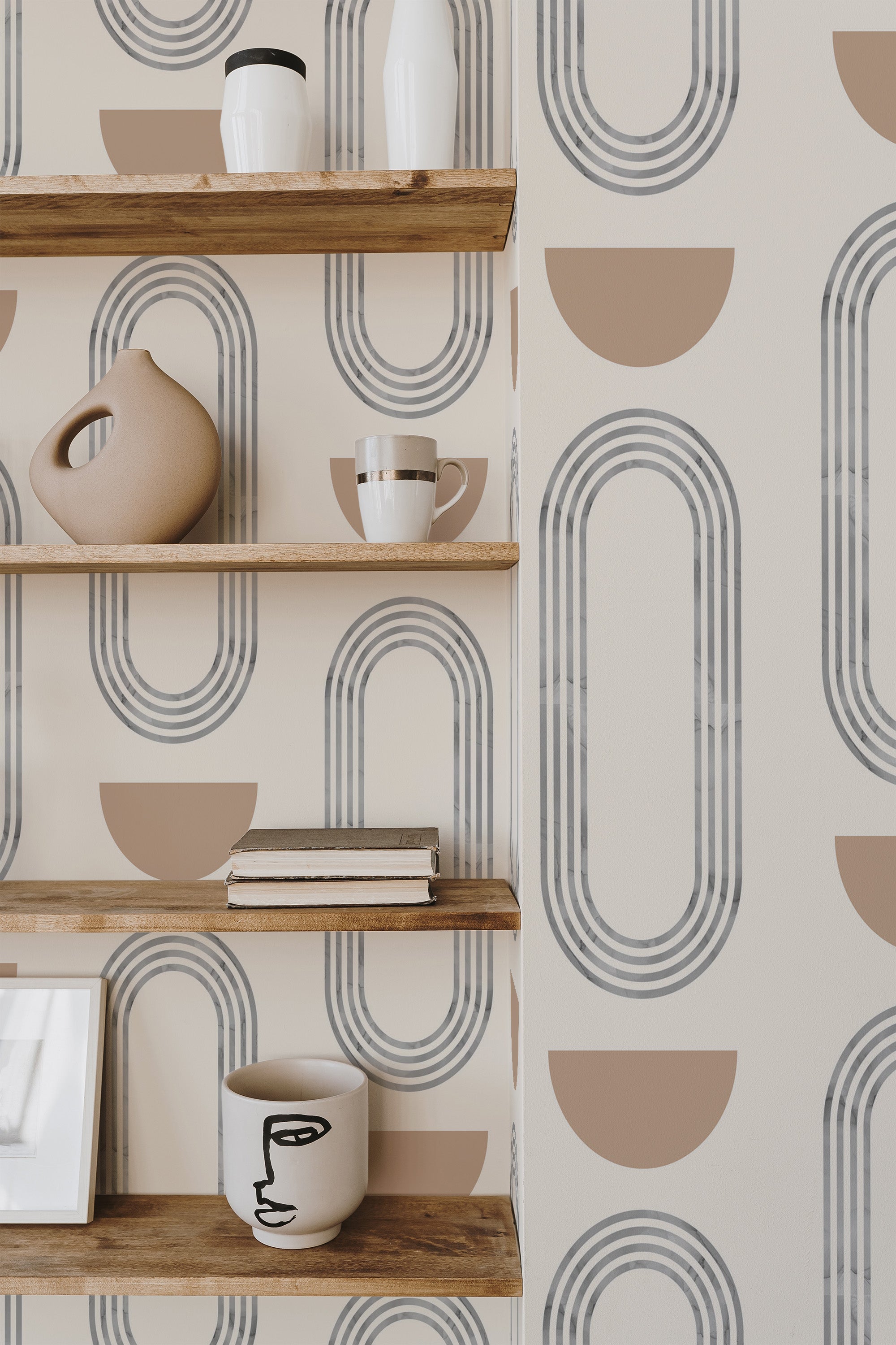 Self-adhesive wallpaper with a Boho circles design, combining oval shapes in light grey, interspersed with semi-circles in a warm beige hue on a cream background. The geometric pattern adds a modern, yet earthy vibe to the room. Natural wood floating shelves with minimalist decor items complement the wallpaper, creating a cozy, stylish atmosphere.
