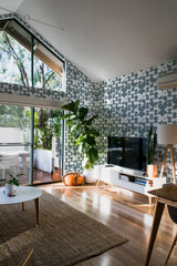 A room with a vintage circle wallpaper design, combining geometric patterns and floral shapes in shades of grey and white, creating a retro yet modern aesthetic on the wall. Traditional wallpaper.