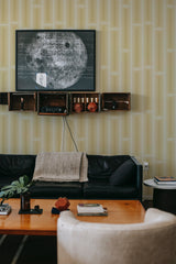 A room with yellow retro geometric wallpaper with a vertical rectangular pattern, creating a subtle yet stylish background that complements the room's modern decor. Traditional wallpaper.