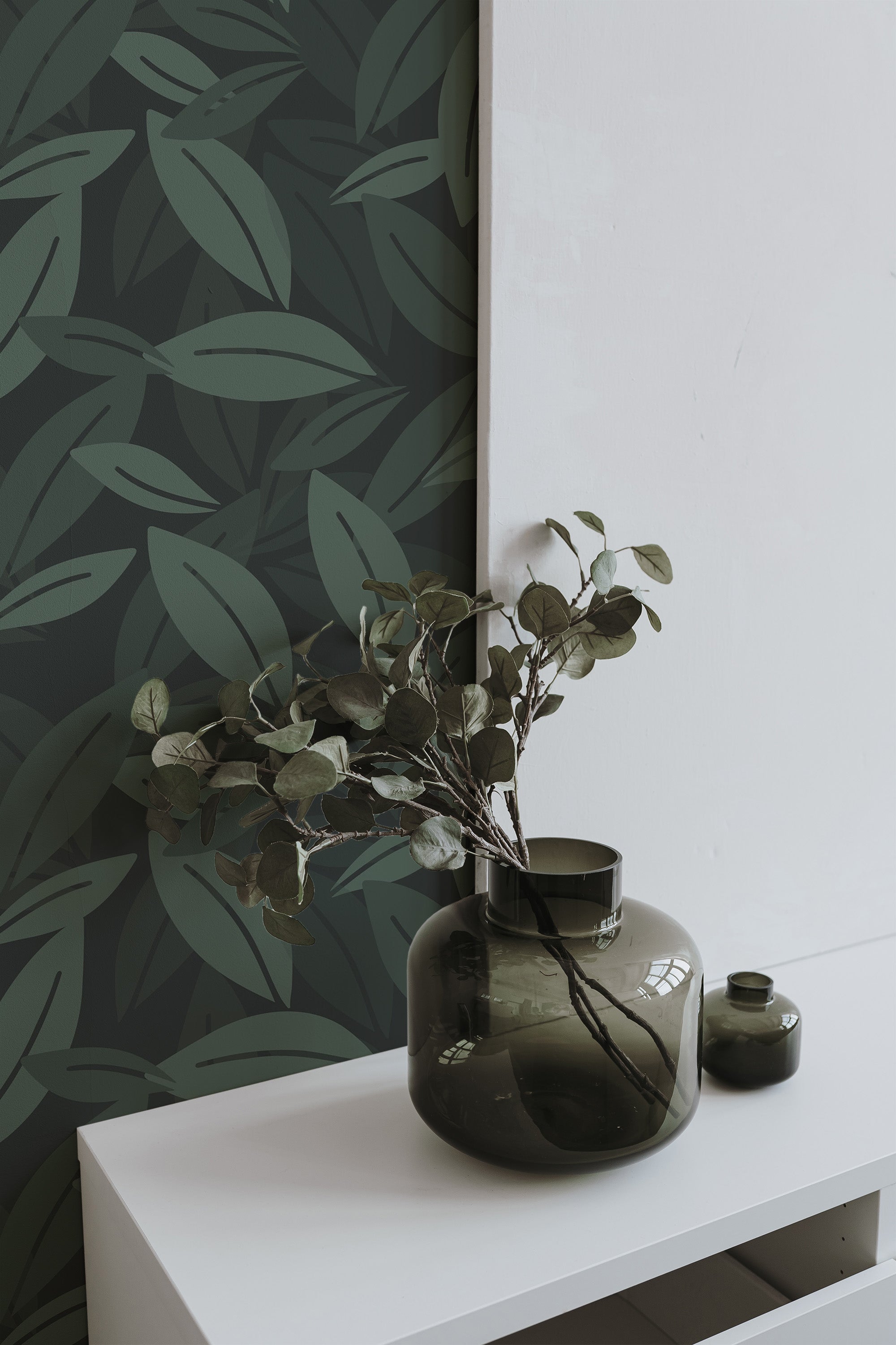 Self-adhesive wallpaper with a bold green leaf pattern on a dark background, creating a natural and calming atmosphere with overlapping leaves.