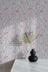 Self-adhesive pastel floral wallpaper with delicate pink flowers and soft green leaves on a light gray background.