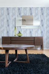 Vertical blue lines in various shades cover the wall, creating a subtle textured pattern in a light and airy room. Traditional wallpaper.