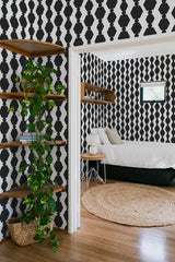 Black bold geometric wallpaper with repeating diamond and hexagon shapes in a striking contrast against a white background in a traditional wallpaper design.