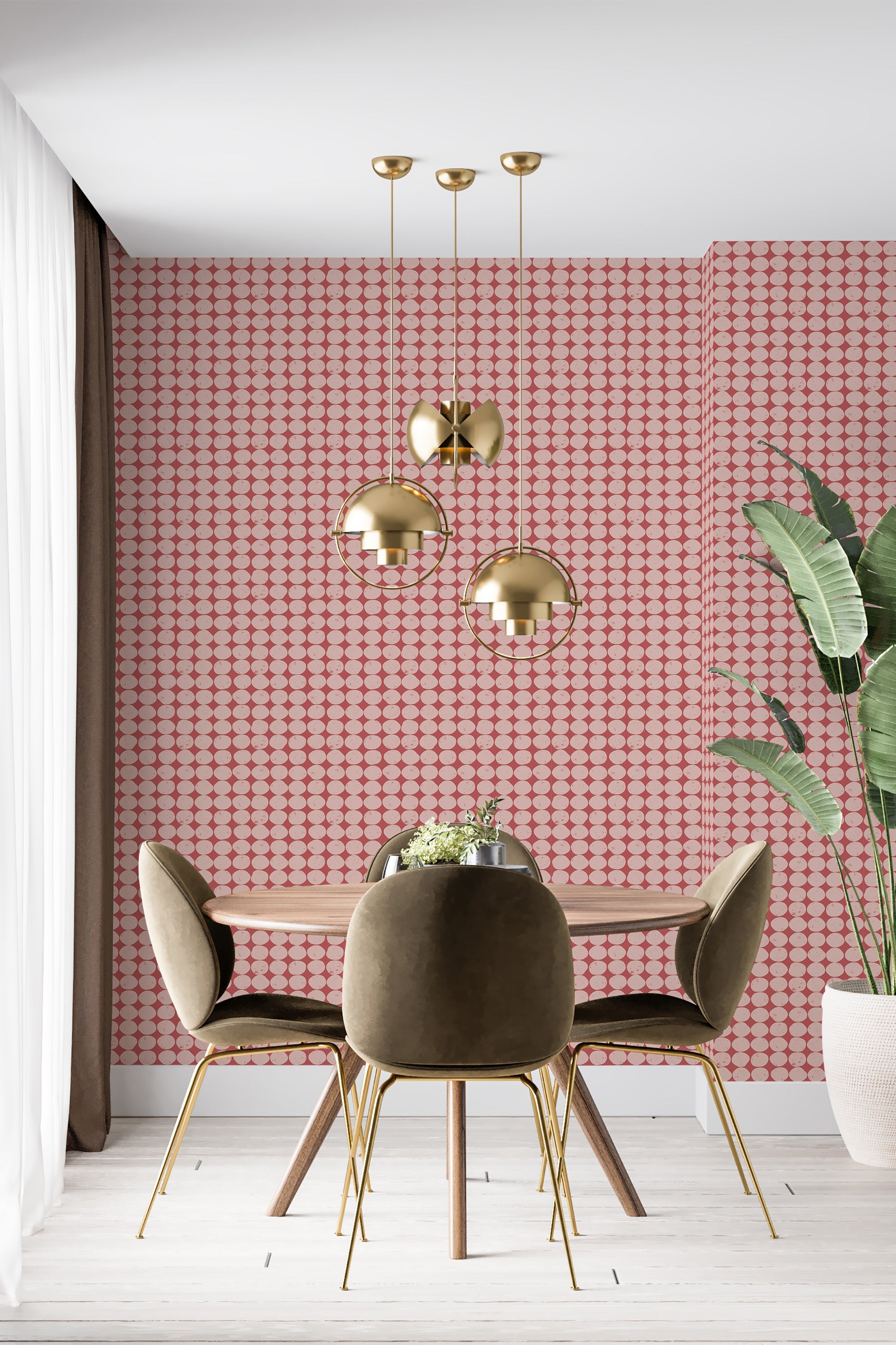 Wallpaper with a pattern of repeating eclectic circles in shades of red and pink, creating a geometric and retro look. Positioned as an accent wall behind a modern dining setup with gold pendant lights and olive green chairs. This is traditional wallpaper.