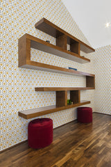 The room has a Honeycomb wallpaper design with interlocking hexagonal shapes in shades of yellow, brown, and white, creating a geometric pattern that adds visual interest and depth. The repeating shapes and classic color palette emphasize a mid-century modern vibe, enhancing the overall decor with traditional wallpaper.