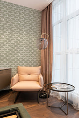 Green and white Retro geometric line wallpaper with a repeating pattern of intersecting curved lines on the wall behind a beige armchair in a cozy room, traditional wallpaper.