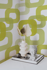 Self-adhesive 60s retro print wallpaper in lime green with continuous interlocking geometric shapes, adding a bold and vintage aesthetic to the room.
