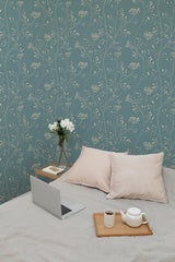 Self-adhesive wallpaper with a Yarrow print in a calming teal hue, adorned with delicate cream botanical patterns of slender branches and small flowering clusters.