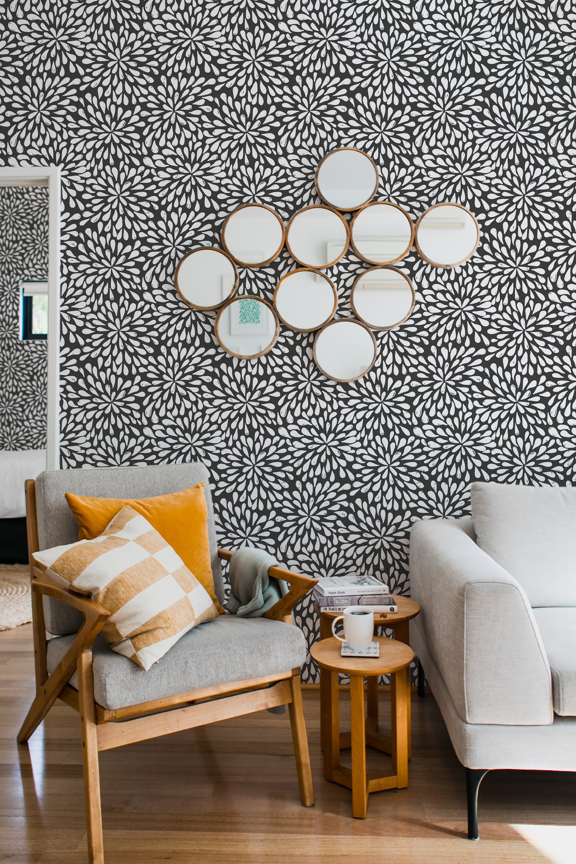 Black and white wallpaper with a bold abstract floral pattern of overlapping large flowers, arranged in a dense, repeating design. The intricate petals create a striking contrast against a dark background, adding a vibrant and dynamic touch to the room. The pattern has a modern take on a traditional wallpaper.