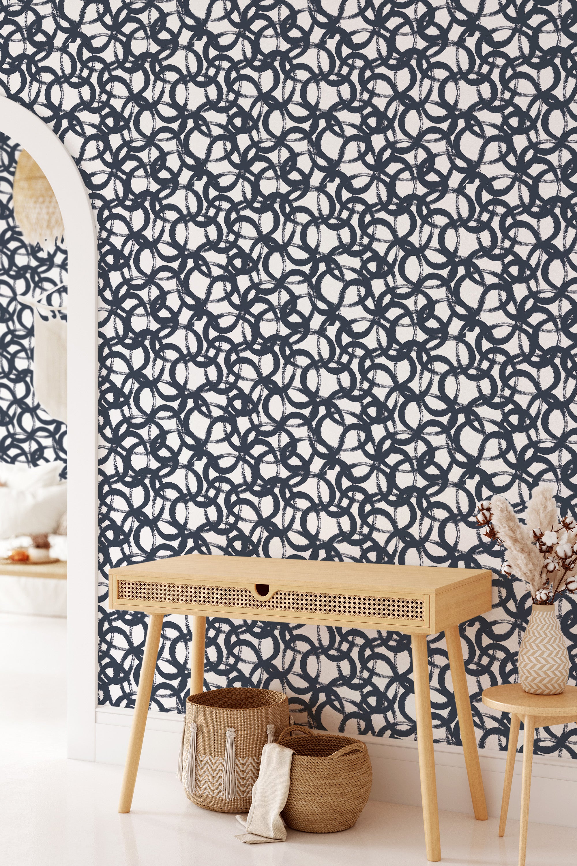 Wallpaper with a bold, repeating navy circular pattern on a white background, creating a striking modern look in a traditionally styled room with light wooden furniture. Traditional wallpaper.