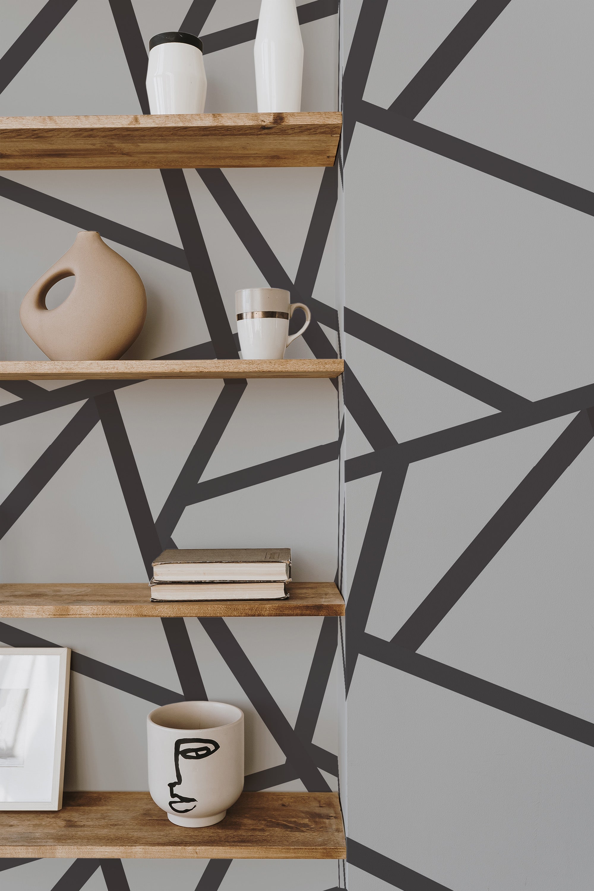 Self-adhesive wallpaper with a bold lines design in black, forming an abstract geometric pattern against a light gray background.