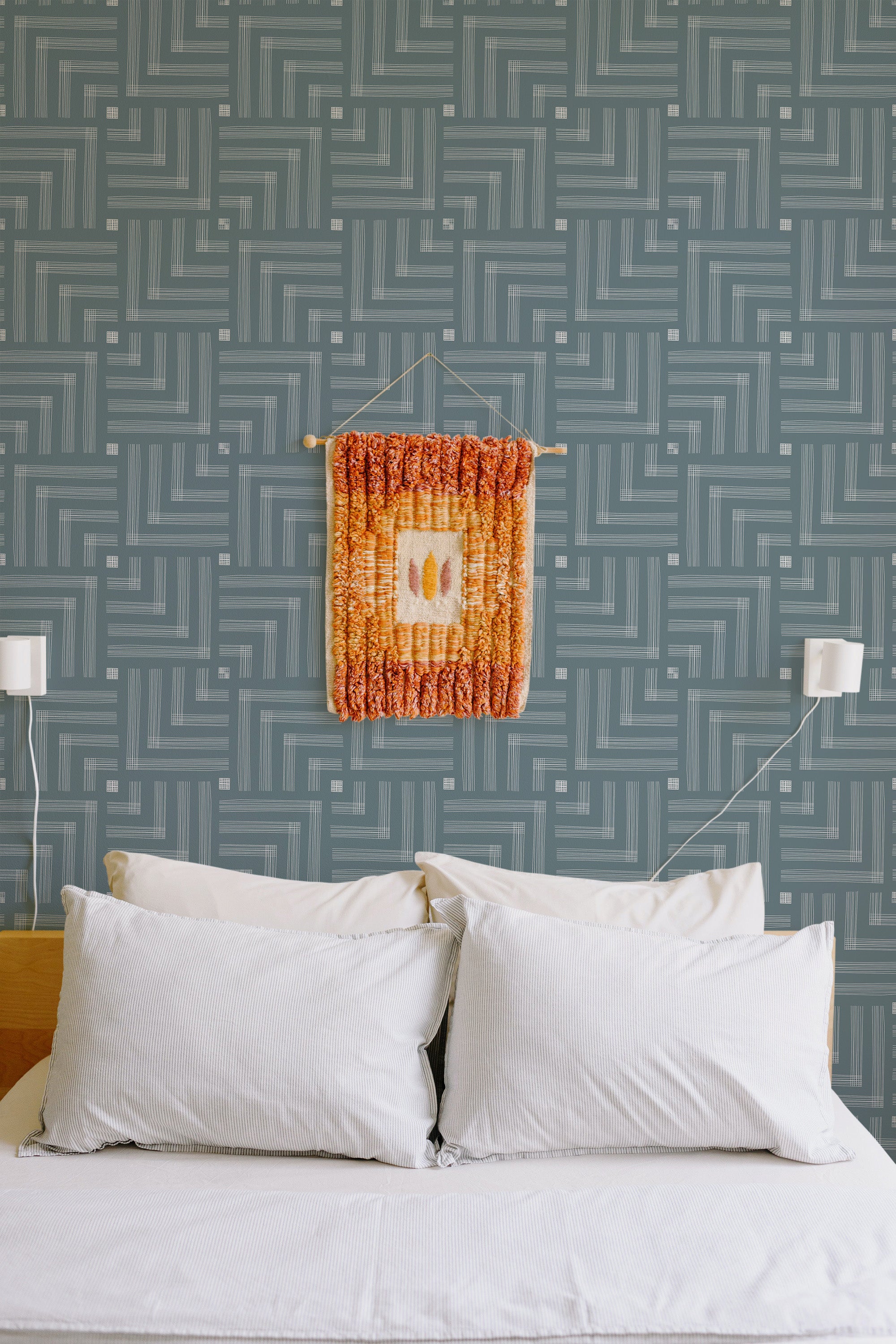 Self-adhesive geometric seamless square wallpaper in shades of gray, providing a modern and abstract aesthetic to a bedroom wall.