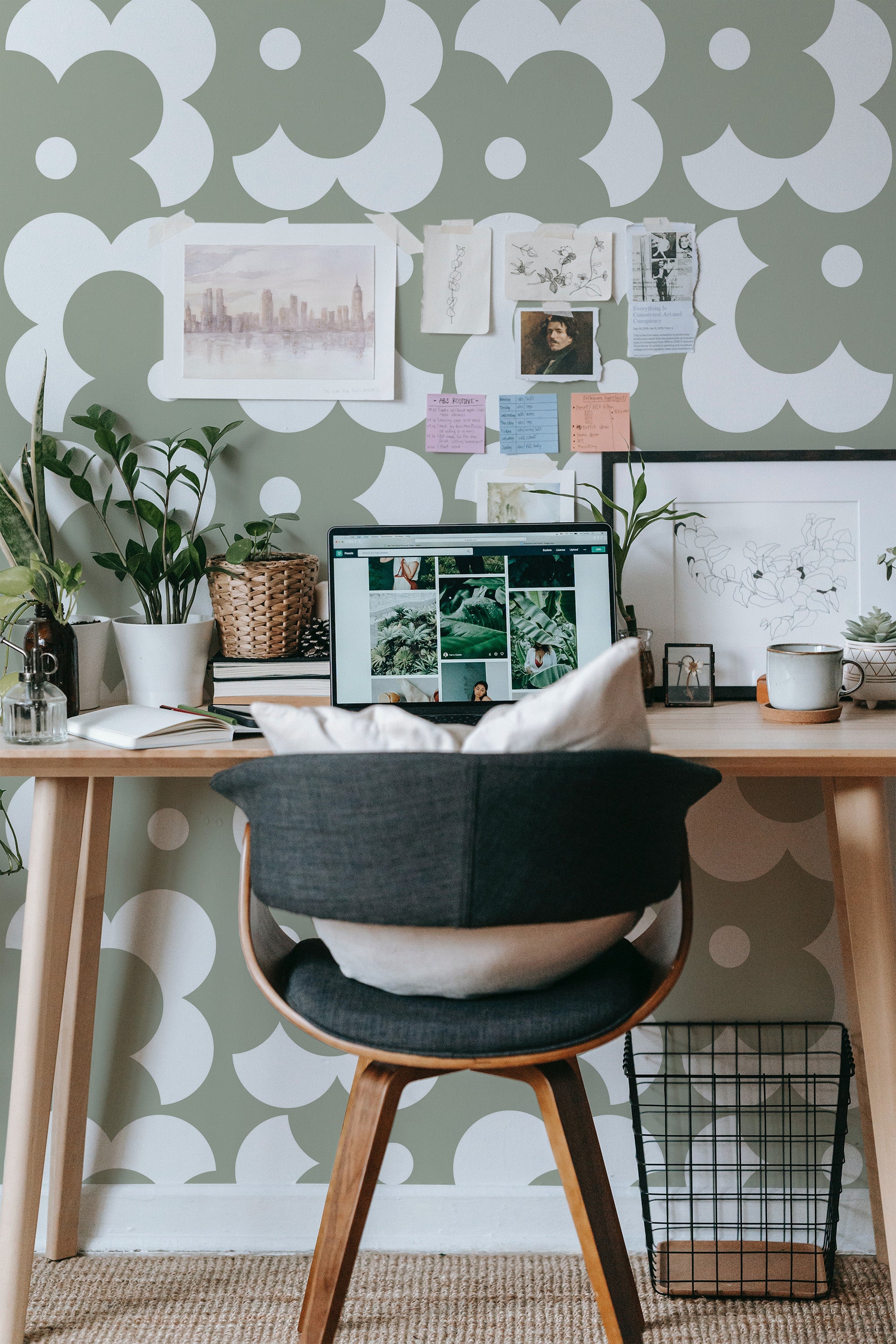Self-adhesive wallpaper with a retro floral pattern in muted green and beige tones, complementing an organized work desk with decor and plants.