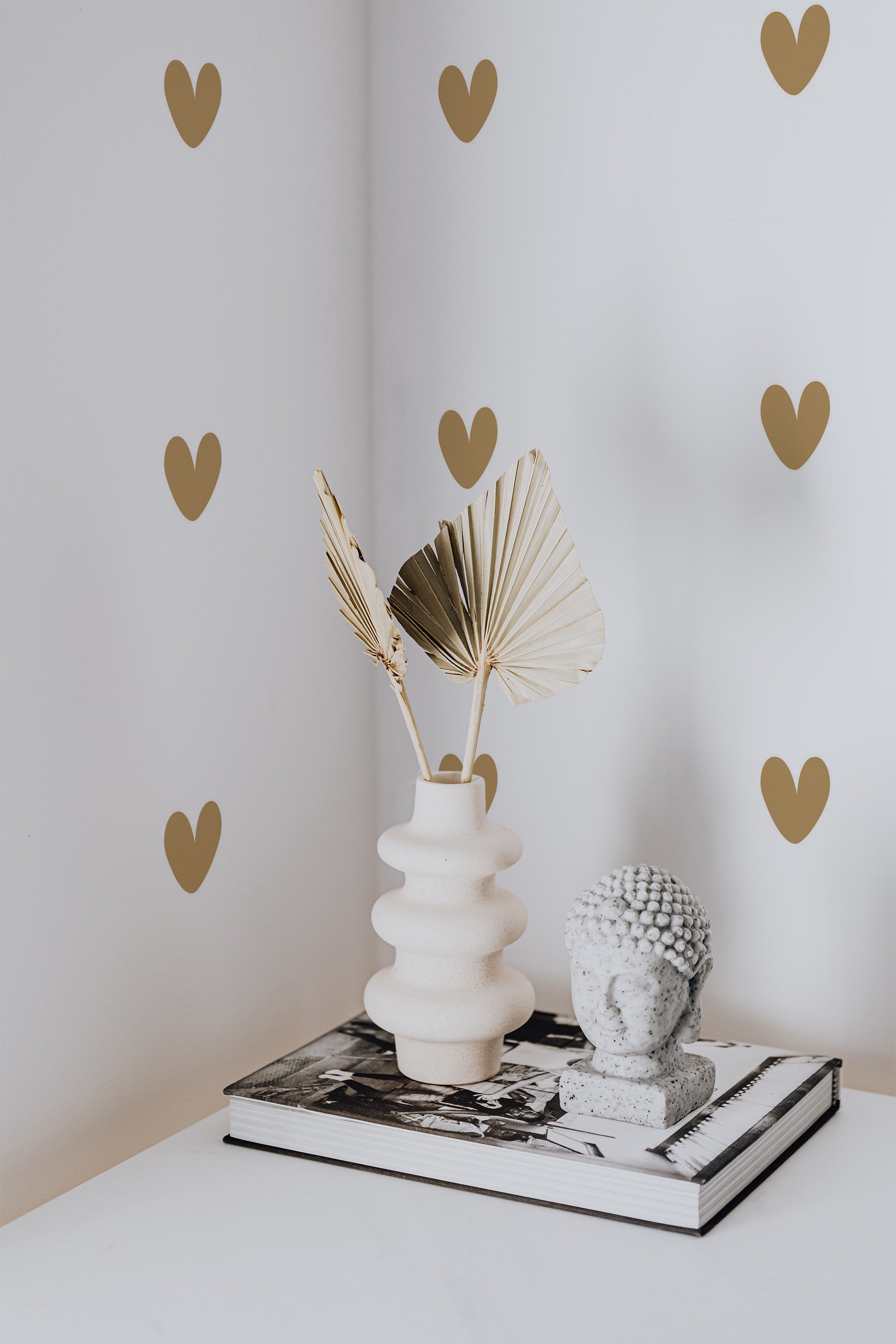 Self-adhesive wallpaper with a repeating pattern of small golden hearts on a light beige background.