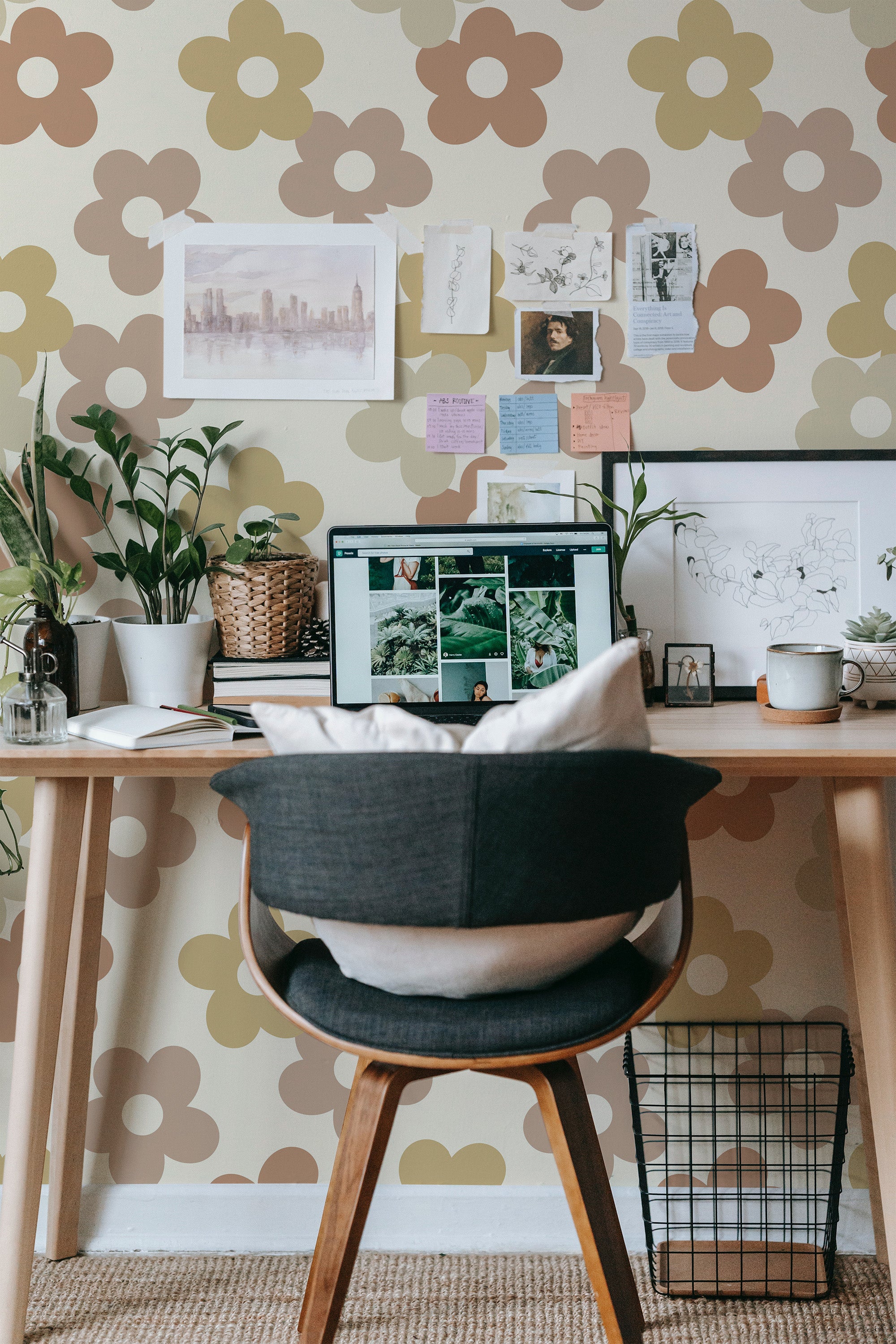 Self-adhesive wallpaper with a simple floral pattern of large brown and beige flowers on a light neutral background in a workspace with a desk and chair.