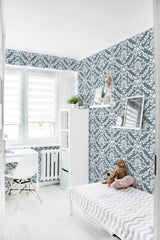 A bright room with a wall covered in blue and white vintage damask pattern wallpaper, giving a classic and elegant feel, traditional wallpaper.