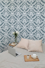 Self-adhesive vintage damask pattern wallpaper in blue and white, with a work setup including a laptop, a teapot on a tray, and cushions.