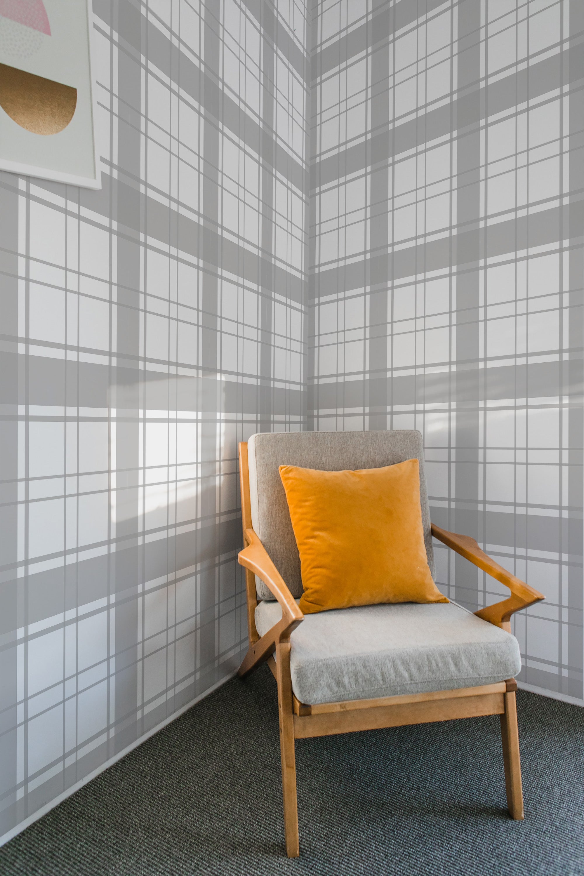 A room with a wall covered in plaid square-patterned wallpaper in neutral tones, complemented by a wooden chair with a yellow cushion, evoking a sense of traditional wallpaper.
