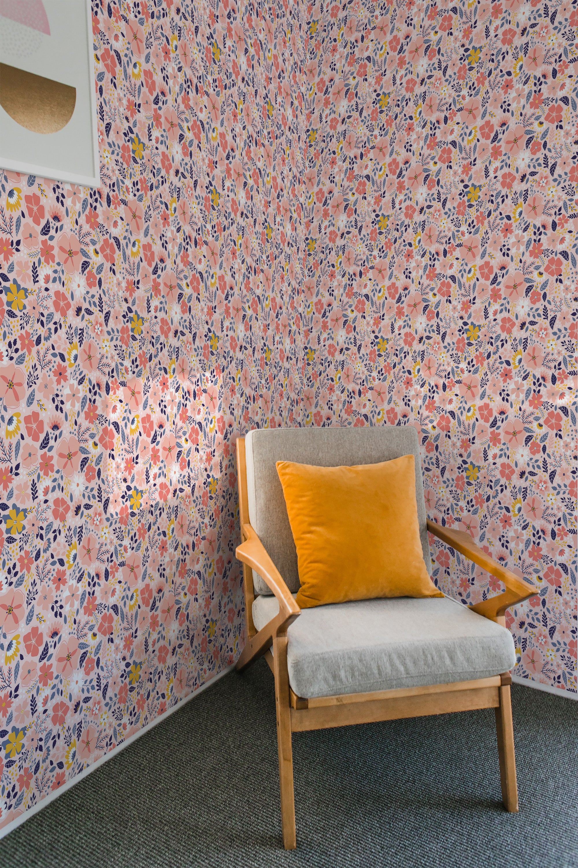 A cozy corner with a wooden armchair against a vibrant Pink Spring wallpaper patterned with pastel pink, orange, and blue flowers on a light background, adding a warm, traditional wallpaper touch.