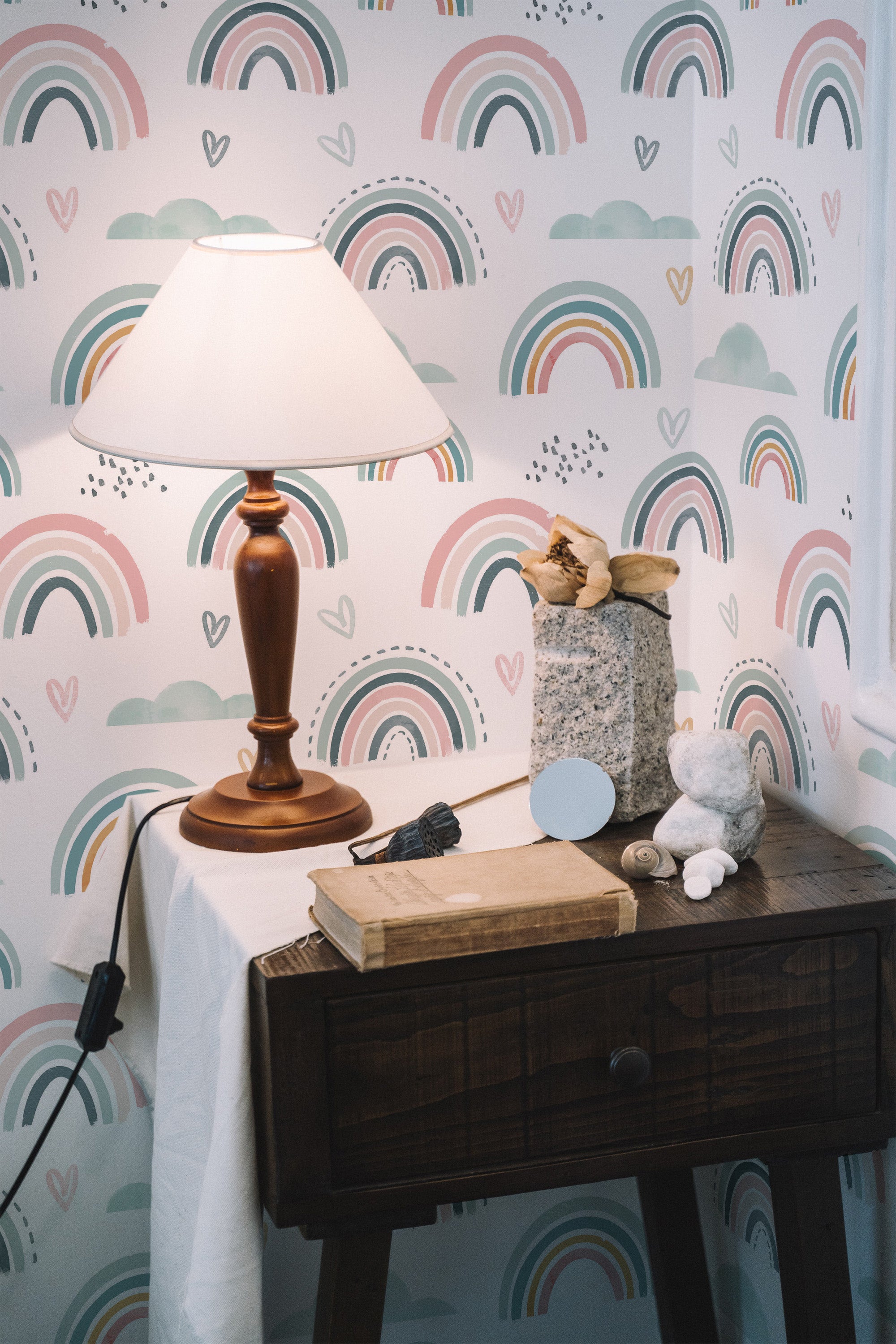 Self-adhesive wallpaper with multicolored rainbow patterns complemented by pastel tones and heart accents on a white background, used in a cozy room setting with wooden furniture and decor.
