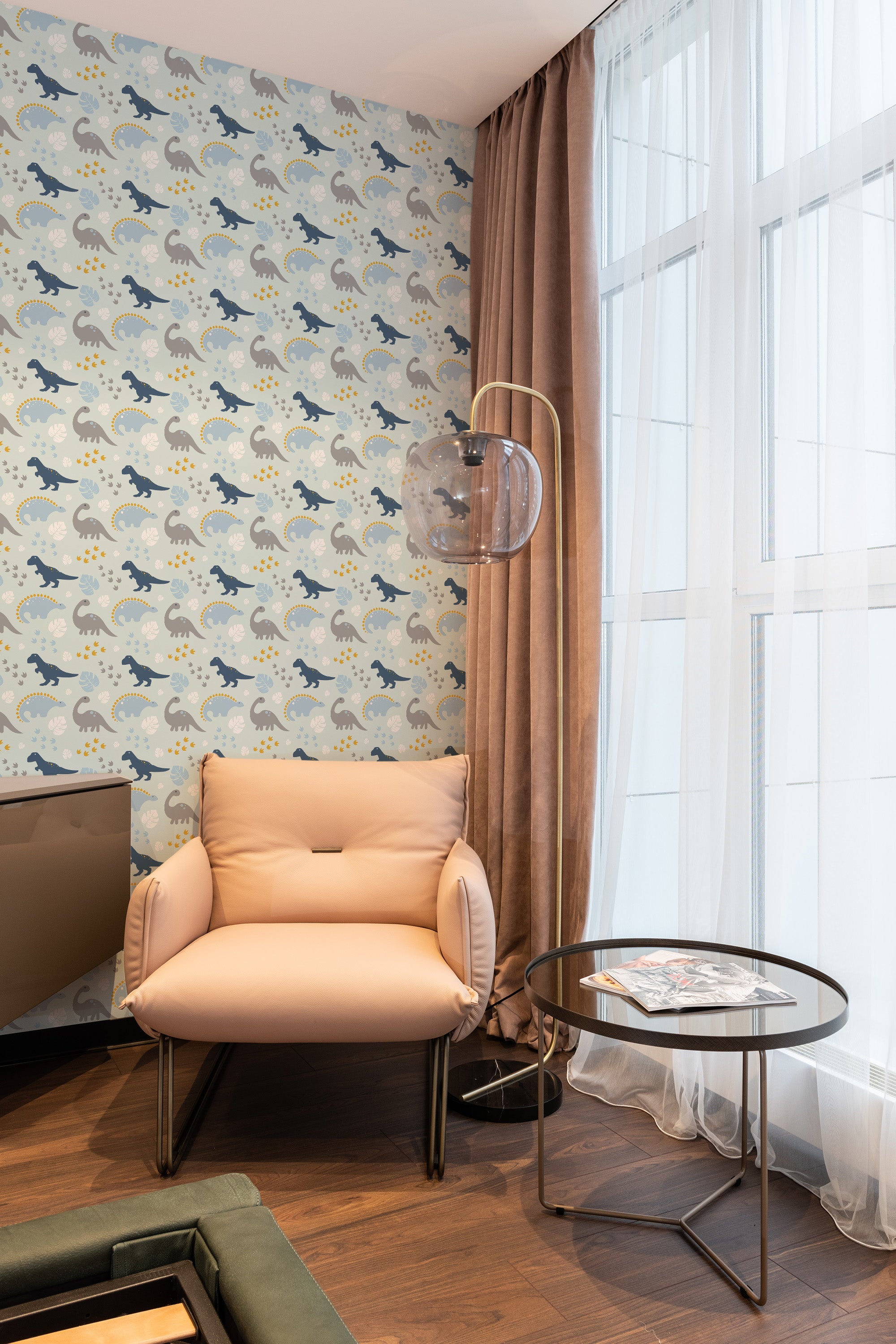 A cozy room corner with Blue Dinosaur patterned wallpaper, showing repeating blue dinosaurs on a light background, paired with brown curtains and a beige armchair, traditional wallpaper.