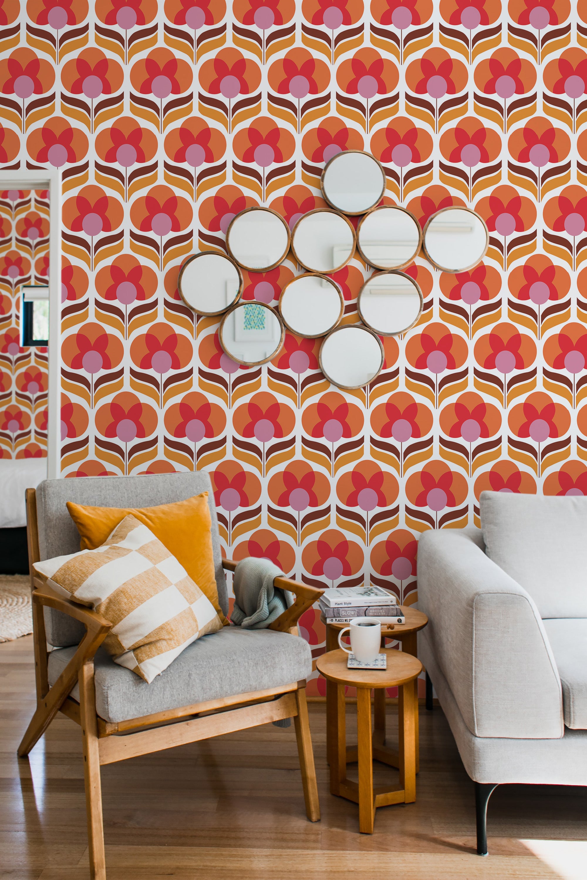 Bright orange and cream retro flower patterns on a wallpaper in a cozy room with modern furniture, completing a vibrant traditional wallpaper aesthetic.