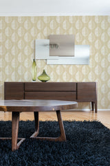 A room with leaf line art-patterned wallpaper in soft beige with yellow leaf outlines, complementing a dark wood console and round table on a shaggy blue rug, traditional wallpaper.