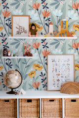 Self-adhesive wallpaper with a floral pattern in hues of blue, orange, and green, accented by shelves with toys and educational posters.
