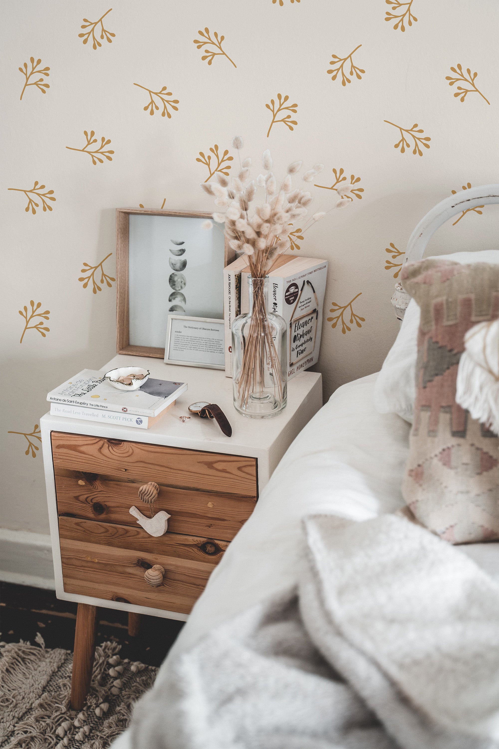 Self-adhesive wallpaper with a minimal tree branch pattern in a cozy bedroom setting with a bedside table and decorative items.