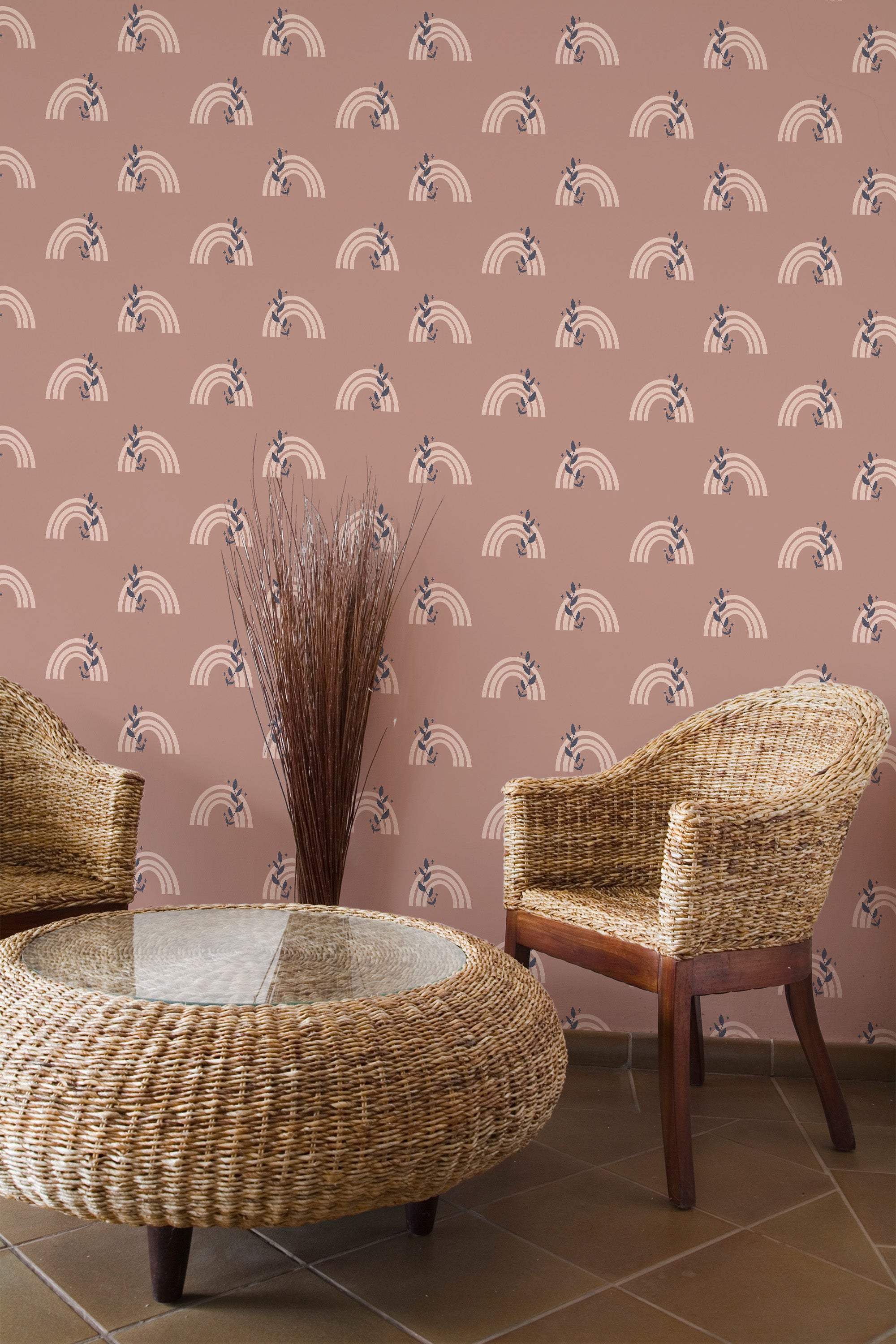 Self-adhesive Boho rainbow patterned wallpaper with arches in alternating shades on a dusty rose background in a room with wicker furniture.