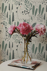 Self-adhesive wallpaper with playful dinosaur illustrations amidst foliage on a neutral background.