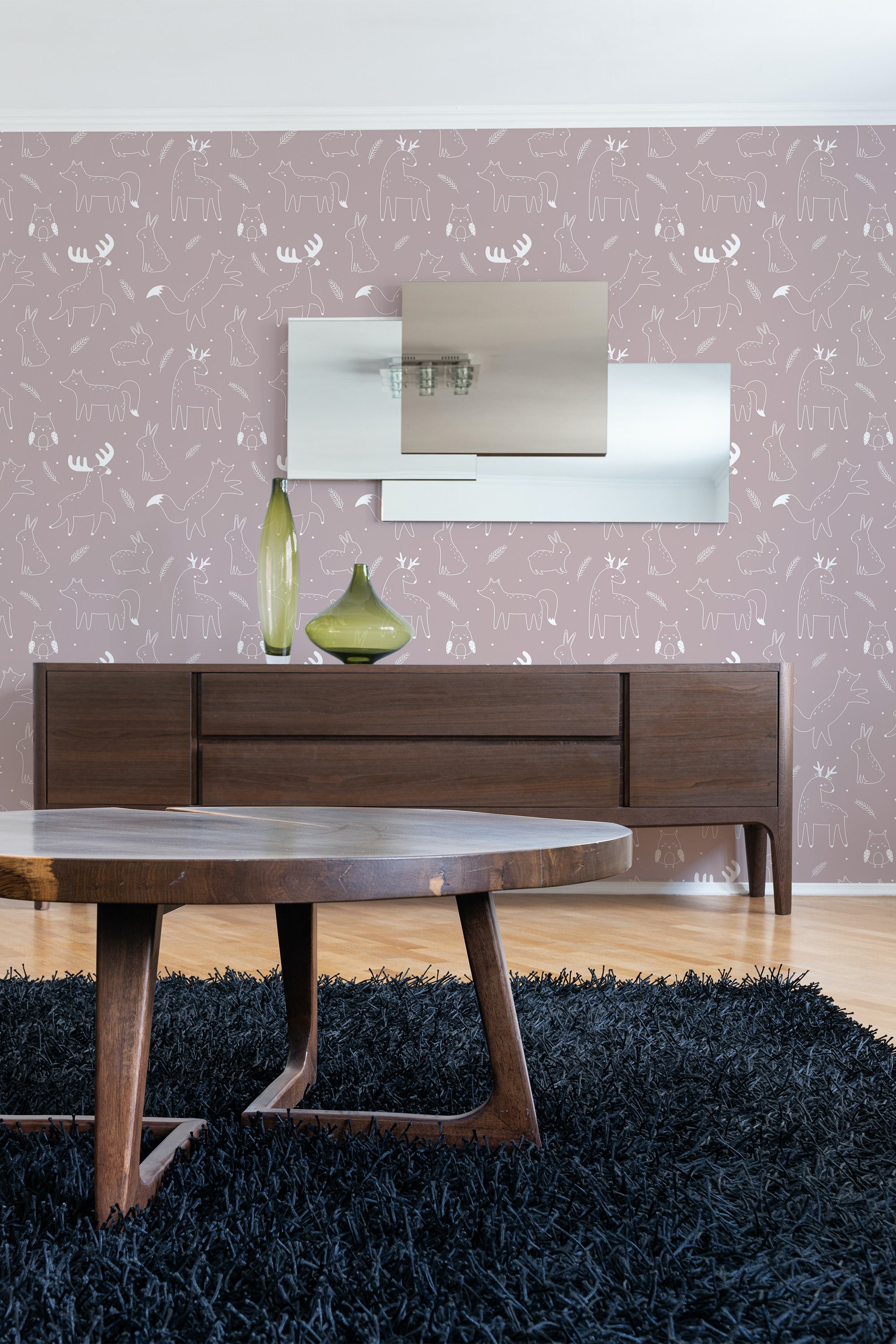 A room with a sideboard and table in front of a wall covered in brown wallpaper with a repeated pattern of white line-drawn forest animals such as deer, rabbits, and squirrels, embodying a traditional wallpaper design.