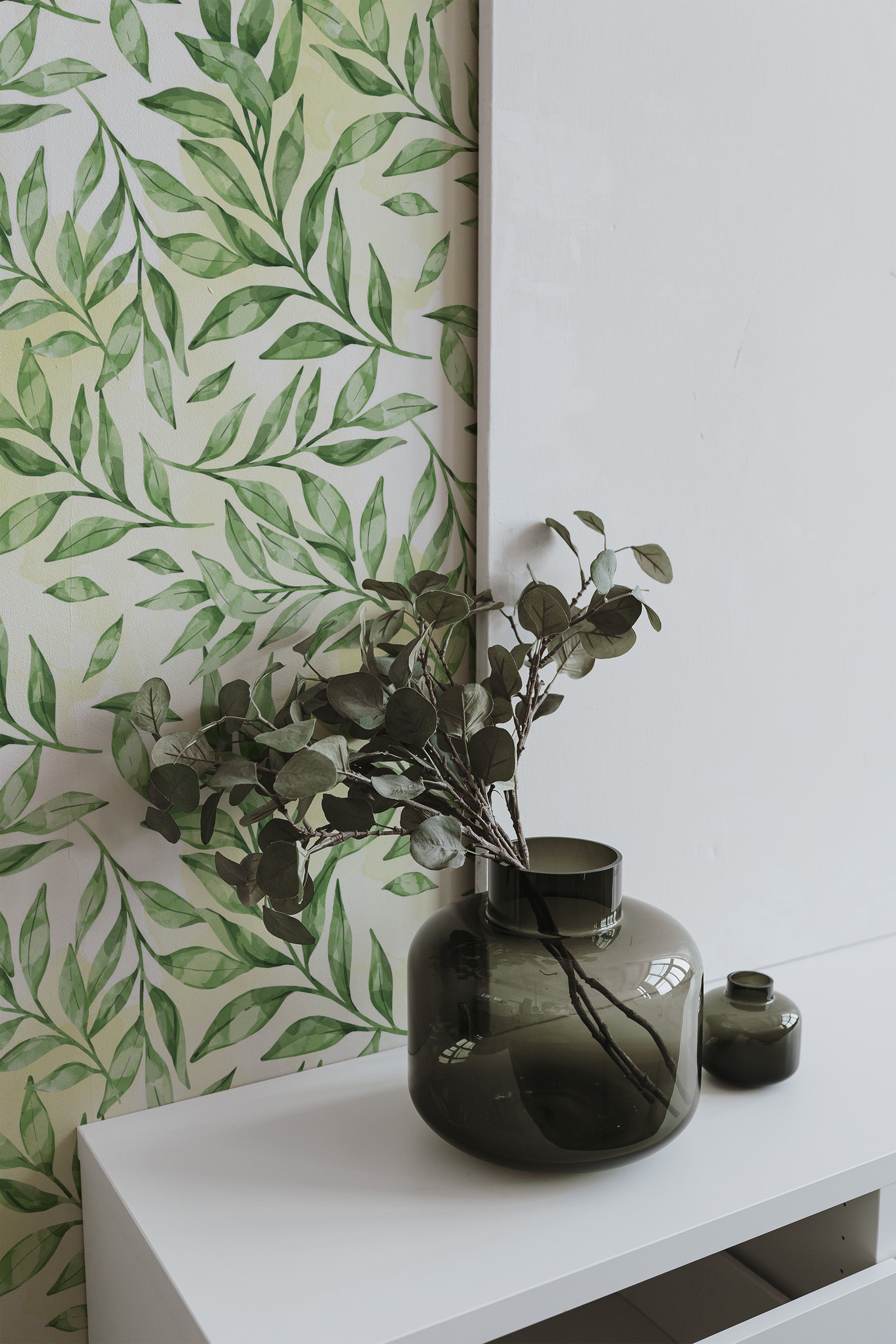 Self-adhesive wallpaper with a natural leaf design in shades of green on a light background, creating a refreshing, botanical atmosphere.