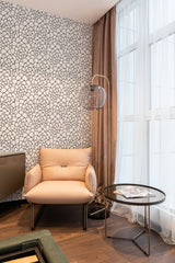Wallpaper with a delicate black and white peacock tail feather pattern, creating an intricate, elegant texture that complements the room's soft and neutral decor. Traditional wallpaper.