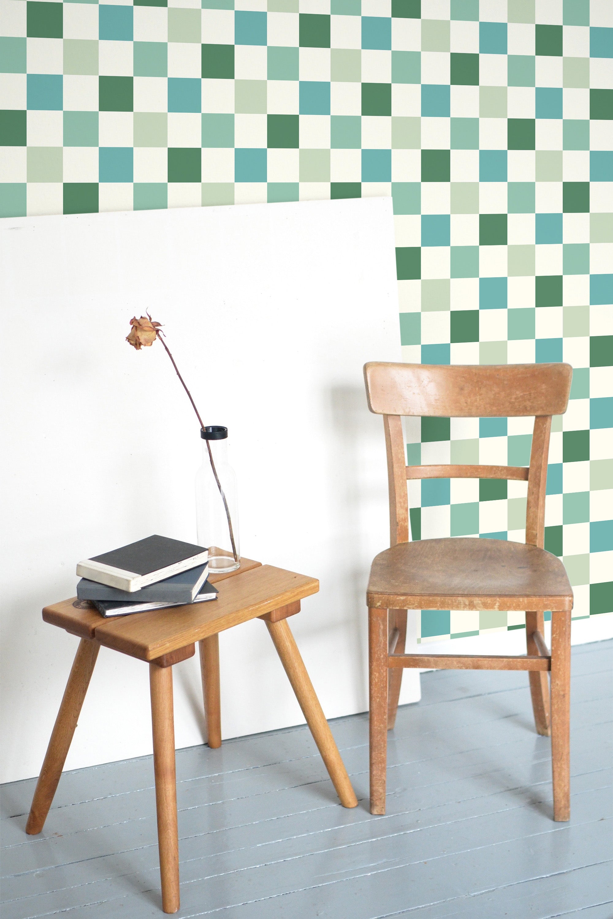 Self-adhesive wallpaper with a green check pattern in various shades, creating a geometric, grid-like design.