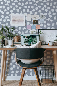 Self-adhesive wallpaper with a Brush dots design in various shades of white and muted grey, creating a pattern of irregular, scattered shapes on a solid background.