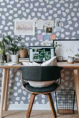 Self-adhesive wallpaper with a Brush dots design in various shades of white and muted grey, creating a pattern of irregular, scattered shapes on a solid background.