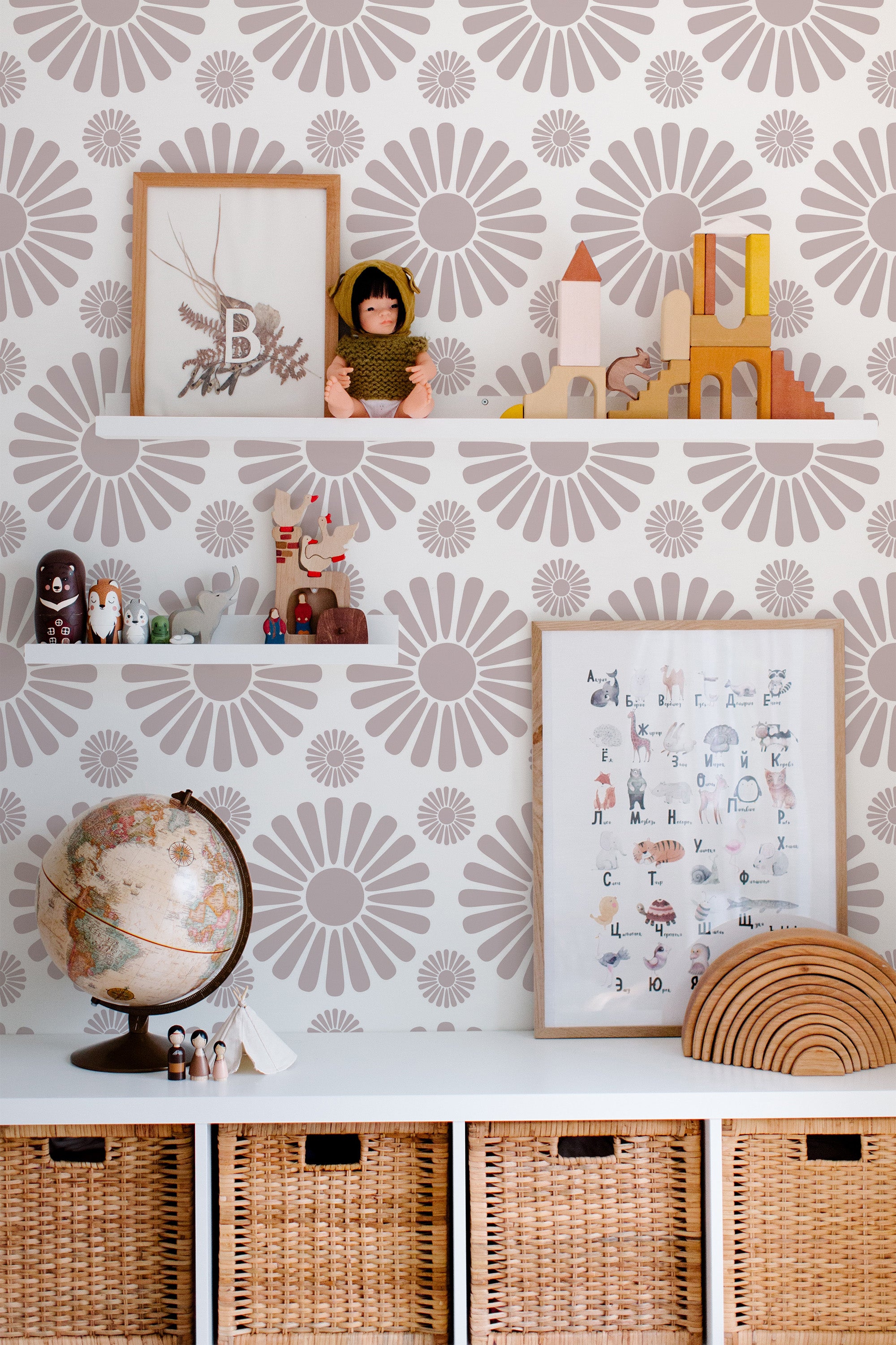 Self-adhesive wallpaper with a flower pattern in muted shades of taupe and gray, covering the wall behind white shelves. The floral design adds a retro-inspired touch, complementing the room's natural wicker baskets and neutral-colored decor.