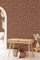 A wall covered with brown wallpaper that has a repeating coffee bean pattern, creating a warm and cozy atmosphere. The intricate design contributes to a classic and inviting ambiance, capturing the richness of coffee culture in a traditional wallpaper.