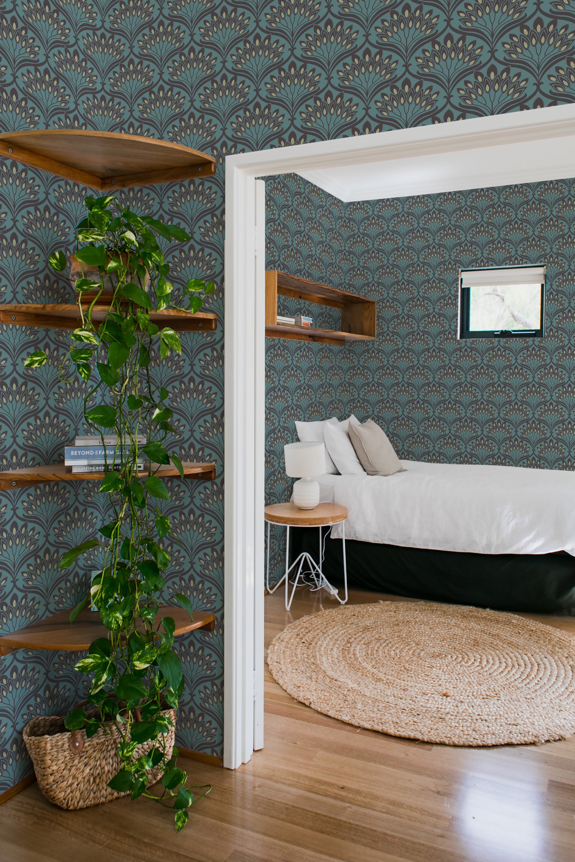 A room with a Dark Retro arch-designed wallpaper illustrating symmetrical, fan-like patterns in contrasting dark and light tones, creating a bold and classic look. The vibrant wallpaper adds depth and a nostalgic feel to the space, complemented by wooden shelves and greenery. The room overall exudes a vintage charm with traditional wallpaper.