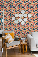Wallpaper with bold, colorful geometric shapes in various patterns and overlapping curves. The design uses a mix of orange, pink, navy blue, and beige tones with a retro, funky aesthetic. The shapes create a vibrant, dynamic effect across the wall, adding a lively and modern touch to the interior. Traditional wallpaper.