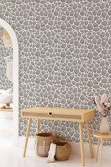 A room with stone-patterned wallpaper, featuring an irregular arrangement of gray stones accentuated by white grout lines, creating a natural, organic look. Traditional wallpaper.