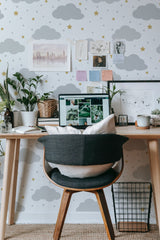 Self-adhesive wallpaper with a cloud design in various shades of gray, with small yellow stars scattered throughout a white background.