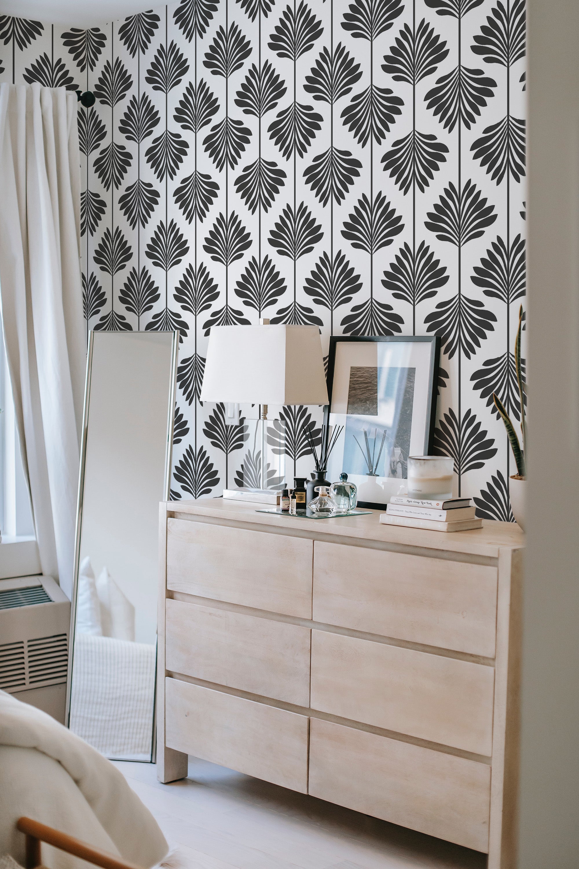 Wallpaper with a repeating pattern of stylized black leaves on a white background, enhancing the room's decor with a timeless, traditional wallpaper.