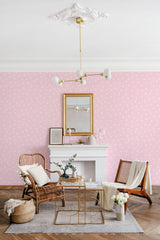 Pink wallpaper with a repeating pattern of small white hearts, creating a soft and charming ambiance in the room. Traditional wallpaper.