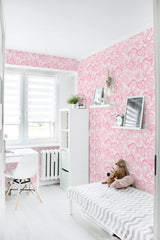 The image shows pink and white hearts in various sizes scattered across a light pink background, covering the walls of a room. This traditional wallpaper adds a playful and cozy vibe to the space.