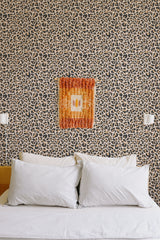 Self-adhesive wallpaper with a leopard pattern in tan and black tones, giving a bold and textured feel to the room's wall.