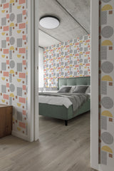 A room with wallpaper in a Boho circle design, featuring various geometric shapes in muted tones of pink, yellow, grey, and beige, covering the walls. Traditional wallpaper.